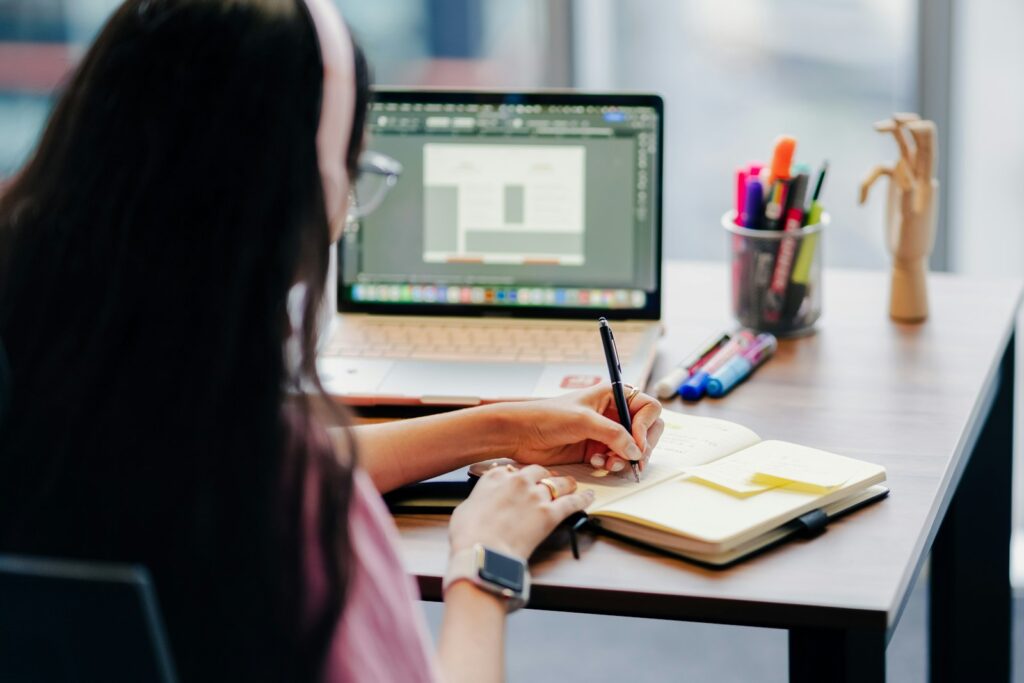 Woman at a desk with a laptop and notebook, ready to learn something new