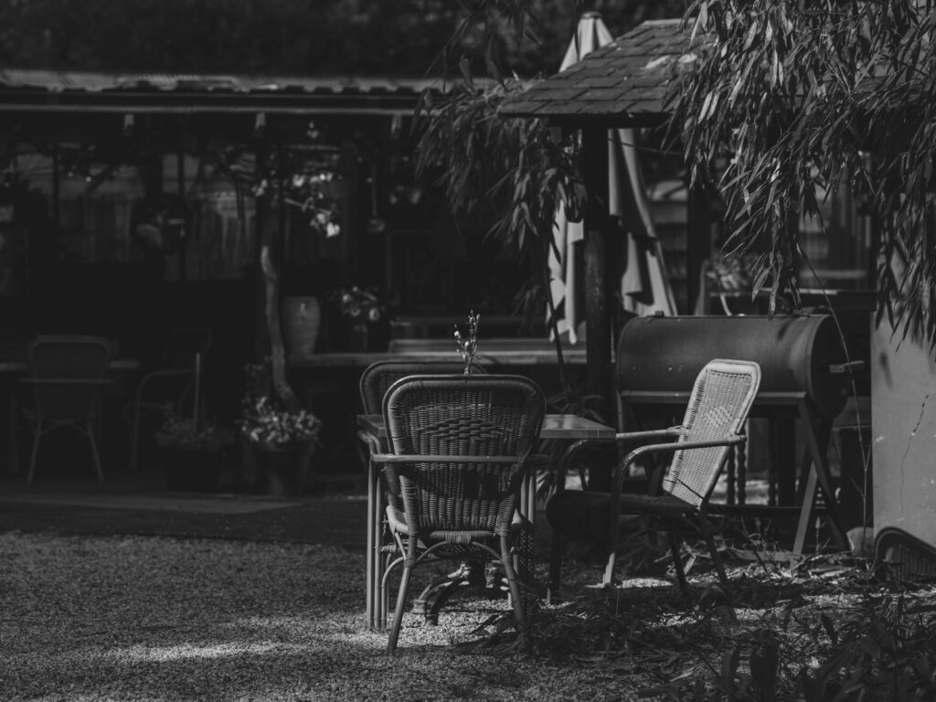 Black and white outdoor patio with a table, chairs and grill for garden entertaining