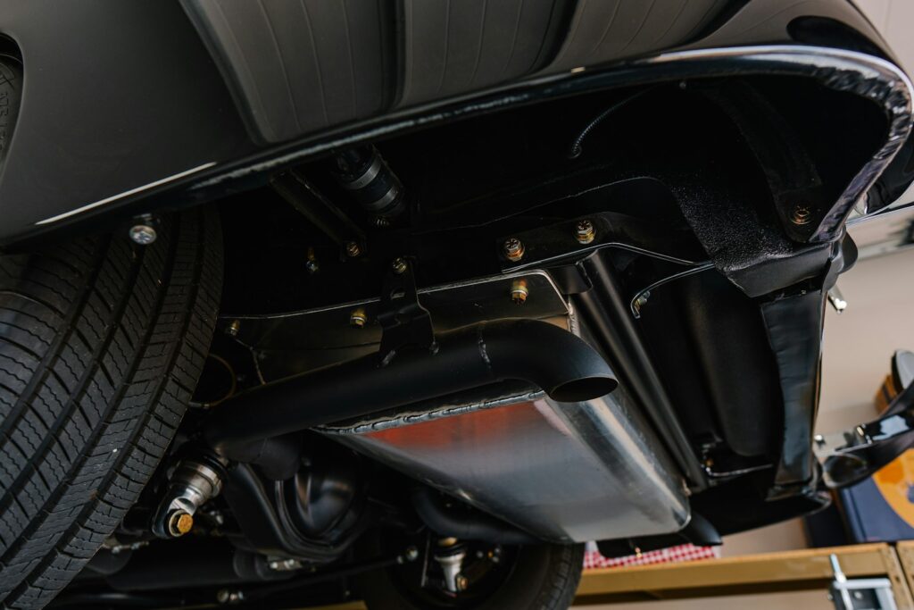 Underside of a black classic car, relevant to checking older vehicles' steering components