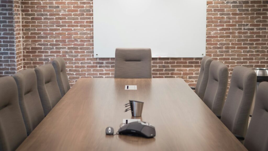 Conference room with chairs around a large table and a projector screen