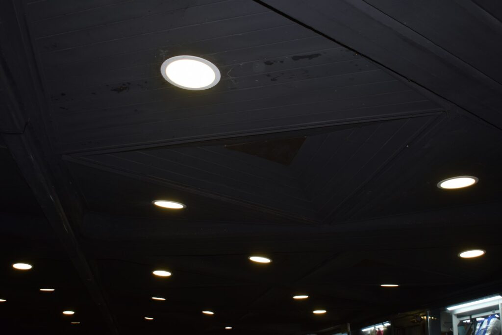 Recessed ceiling lights illuminating a dark space, as found with downlights in a ceiling