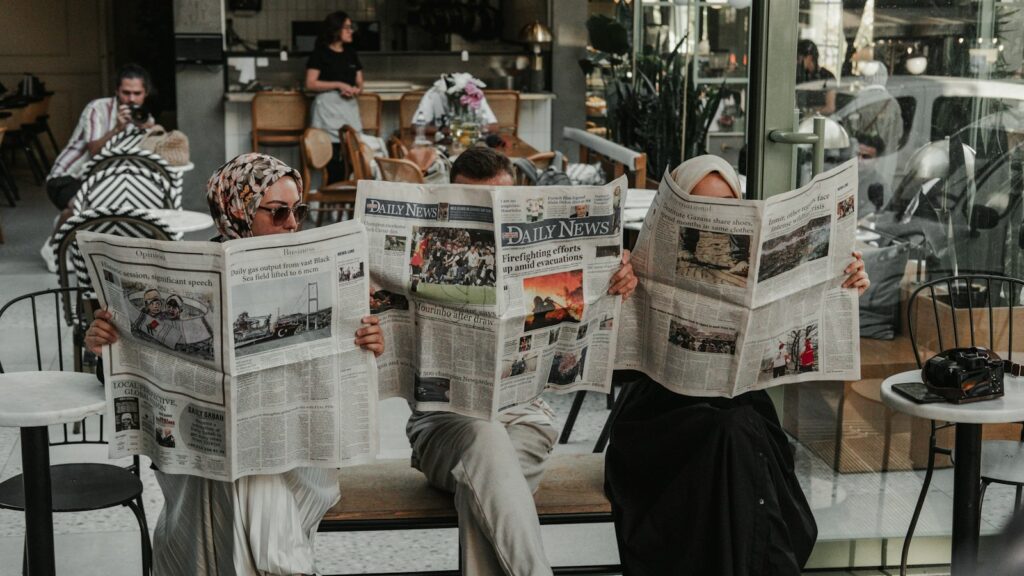 A man sitting on a bench reading a newspaper, taking in the day's news